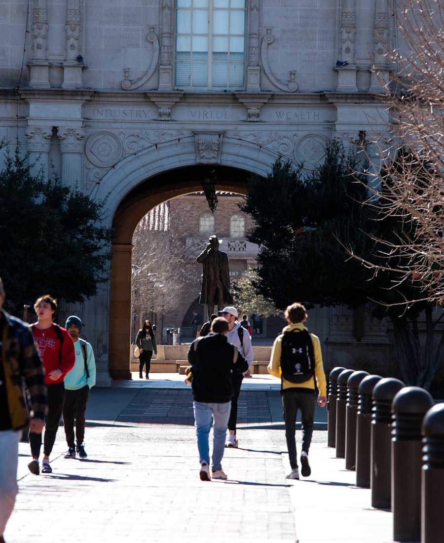 Students walking through a historic university campus archway
